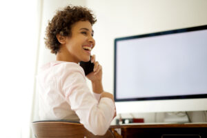 lady on phone smiling at desk